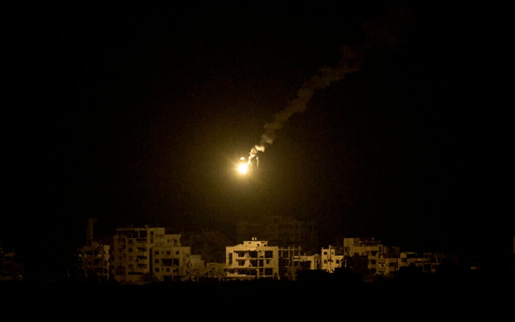 An Israeli army flare drifts over buildings in the northern Gaza Strip, as seen from southern Israel, September 15, 2025. (AP/ Leo Correa)
