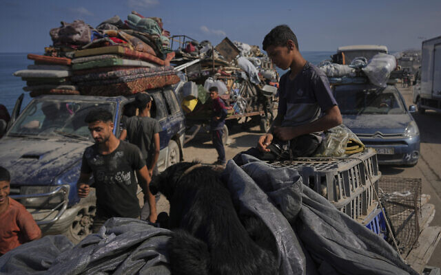 Displaced Palestinians carry their belongings as they flee northern Gaza along the coastal road toward the south, as Israel announced an expanded operation in Gaza City, Sept. 16, 2025. (AP Photo/Abdel Kareem Hana)