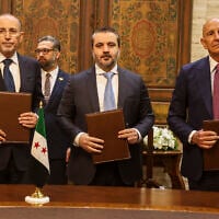 US Ambassador to Turkey and Special Envoy to Syria Tom Barrack, right, Jordanian Foreign Minister Ayman Safadi, left, and Syrian Foreign Minister Asaad al-Shibani pose for a photograph after signing a roadmap to restore security in southern Syria, in Damascus, Syria, September 16, 2025. (AP Photo/Ghaith Alsayed)