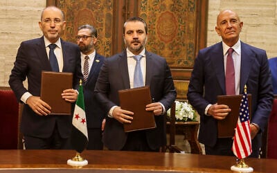 US Ambassador to Turkey and Special Envoy to Syria Tom Barrack, right, Jordanian Foreign Minister Ayman Safadi, left, and Syrian Foreign Minister Asaad al-Shaibani pose for a photograph after signing a roadmap to restore security in southern Syria, in Damascus, Syria, September 16, 2025. (AP Photo/Ghaith Alsayed)