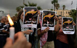 Supporters of Lebanon's Hezbollah group hold candles and posters with Arabic writing that reads "Our eyes, your eyes," during a gathering in Beirut, Lebanon, Wednesday, Sept. 17, 2025, to mark the one-year anniversary of the pager attack carried out by Israel that exploded thousands of pagers and walkie-talkies used by Hezbollah. (AP Photo/Hassan Ammar)
