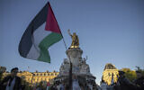 A woman holds a Palestinian flag at Republic Square in Paris, Sep. 17, 2025. (AP Photo/Aurelien Morissard)