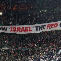 Celtic fans lift a protest banner about Israel during the UEFA Champions League playoff first leg soccer match between Glasgow Celtic and Bayern Munich at the Celtic Park Stadium in Glasgow, Scotland on February 12, 2025. (AP Photo/Scott Heppell)