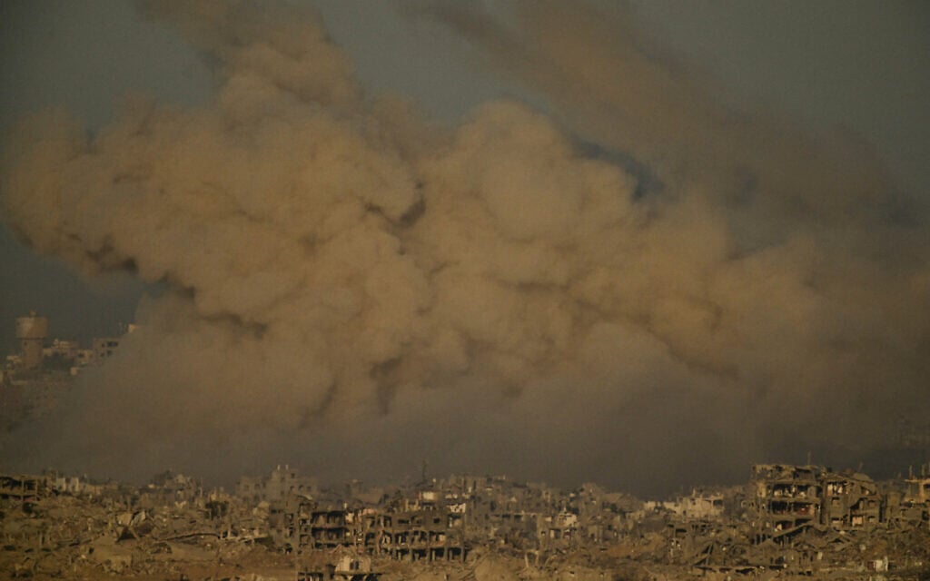 Buildings that were destroyed during the Israeli ground and air operations are engulfed by smoke following an airstrike in the northern Gaza Strip, as seen from southern Israel, September 20, 2025. (AP Photo/Leo Correa)