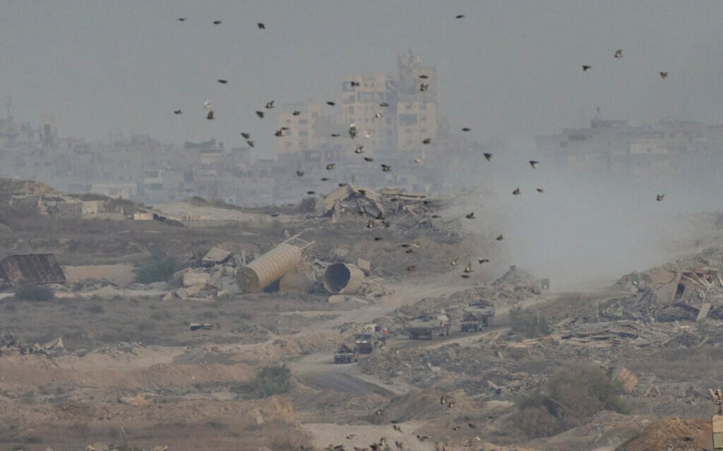 Israeli soldiers drive on their armored personnel carrier inside the northern Gaza Strip, as seen from southern Israel, Sunday, Sept. 21, 2025. (AP/Ohad Zwigenberg)