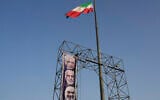 A worker hangs a banner showing portraits of the late Iranian armed forces commanders, Gen. Mohammad Hossein Bagheri, top, Gen. Gholamali Rashid, center, and Gen. Hossein Salami who were killed in Israeli strikes in June at Baharestan Square in Tehran, Monday, Sept. 22, 2025. (AP Photo/Vahid Salemi)