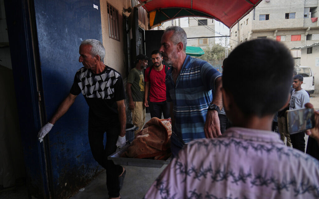 Palestinians carry the body of a family member killed in an Israeli military strike, at the Al-Aqsa Hospital in Deir al-Balah, central Gaza Strip, Wednesday, Sept. 24, 2025. (AP Photo/Abdel Kareem Hana)