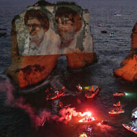Portraits of former Hezbollah leaders Hassan Nasrallah, right, and Hashem Safieddine, are projected onto the landmark Raouche sea rock during an event commemorating their deaths in Israeli airstrikes nearly a year ago, in Beirut, Lebanon, September 25, 2025. (AP/Hussein Malla)