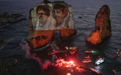 Portraits of former Hezbollah leaders Hassan Nasrallah, right, and Hashem Safieddine, are projected onto the landmark Raouche sea rock during an event commemorating their deaths in Israeli airstrikes nearly a year ago, in Beirut, Lebanon, September 25, 2025. (AP/Hussein Malla)