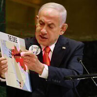 Prime Minister Benjamin Netanyahu holds up a map while speaking at the 80th session of the United Nations General Assembly, Friday, Sept. 26, 2025, at U.N. headquarters. (AP Photo/Stefan Jeremiah)