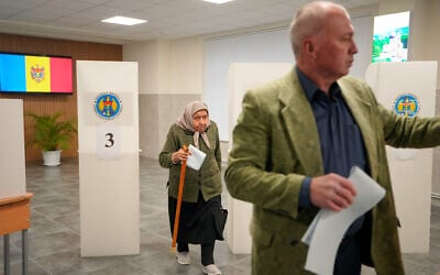 A woman exiting a voting booth waits in line to cast her vote during a parliamentary election, in Chisinau, Moldova, September 28, 2025. (AP Photo/Vadim Ghirda)