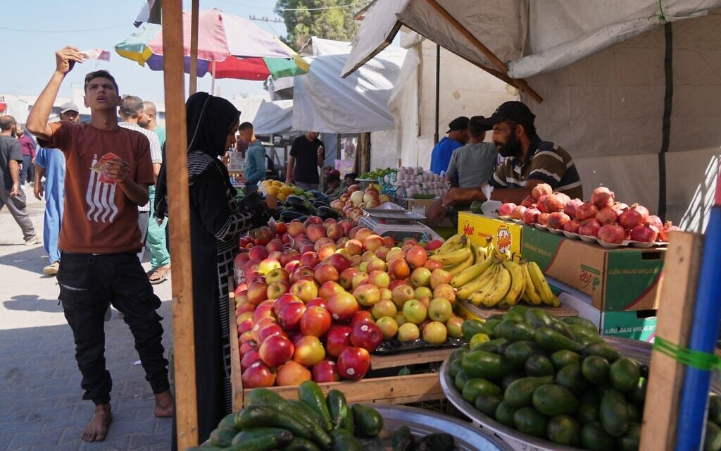 A man reviews a bill while purchasing food at a fruit stand in Khan Younis on Tuesday, Sept. 30, 2025. (AP/Jehad Alshrafi)