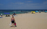 Israelis and tourists enjoy the beach in Caesarea on August 21, 2023. 
(Michael Giladi/Flash90)