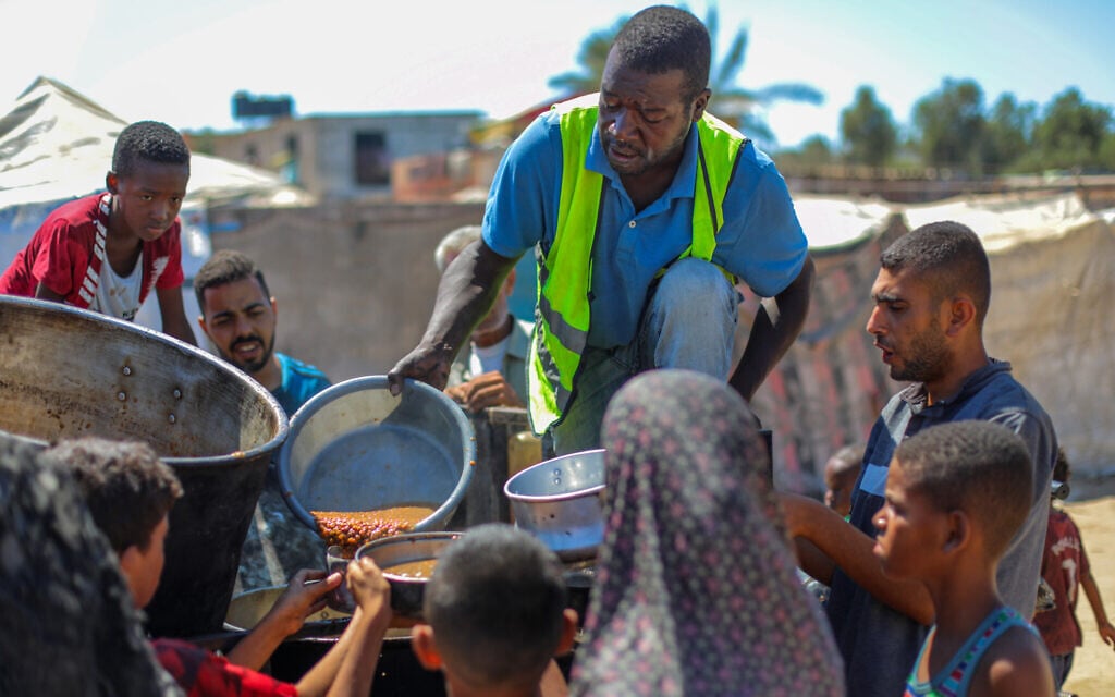 Palestinians receive meals from volunteers in Gaza City, September 1, 2025. (Ali Hassan/Flash90)