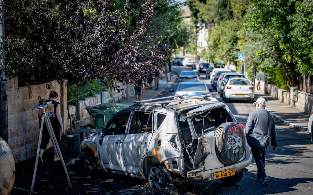 A car burned after a recycling bin was set on fire by protesters demanding the release of the hostages held in Gaza, near the prime minister’s residence in Jerusalem, September 3, 2025. (Chaim Goldberg/Flash90)