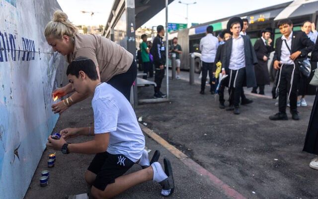 People light candles at the site of a terror attack at Ramot junction in Jerusalem on September 8, 2025. (Chaim Goldberg/FLASH90) People light candles at the site of a terror attack at Ramot junction in Jerusalem on September 8, 2025. (Chaim Goldberg/FLASH90)