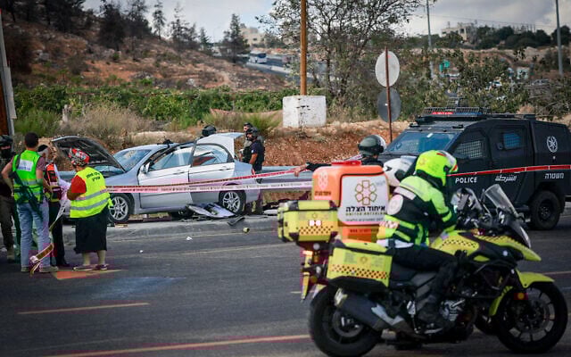 Police and rescue personnel at the scene of a car-ramming terror attack where two teens were injured, on a West Bank highway near Jerusalem. September 30, 2025. (Chaim Goldberg/Flash90)