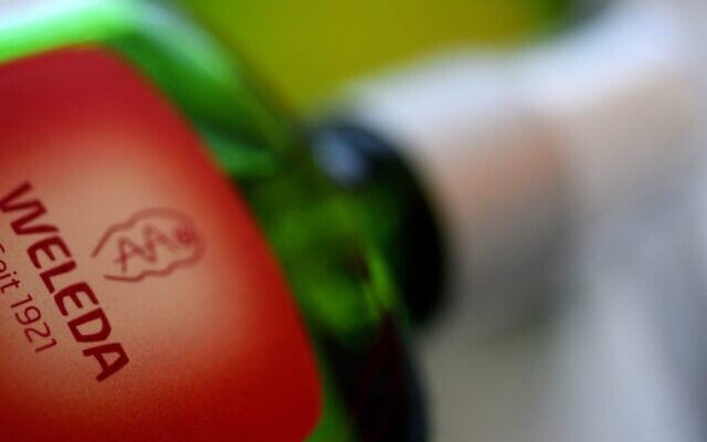The company logo of Weleda is on a glass bottle. Weleda produces herbal medicines and cosmetics. (Stefan Puchner/picture alliance via Getty Images via JTA)