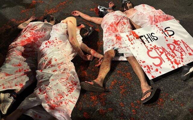 Protesters demanding a hostage-ceasefire deal lay on the ground while dressed in bloody togas outside the prime minister's residence on September 17, 2025. (Charlie Summers/Times of Israel) Protesters demanding a hostage-ceasefire deal lay on the ground while dressed in bloody togas outside the prime minister's residence on September 17, 2025. (Charlie Summers/Times of Israel)