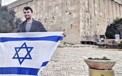 Charlie Kirk holds an Israeli flag outside the Cave of the Patriarchs in Hebron in the West Bank in an undated image (Itamar Ben Gvir/X via JTA)