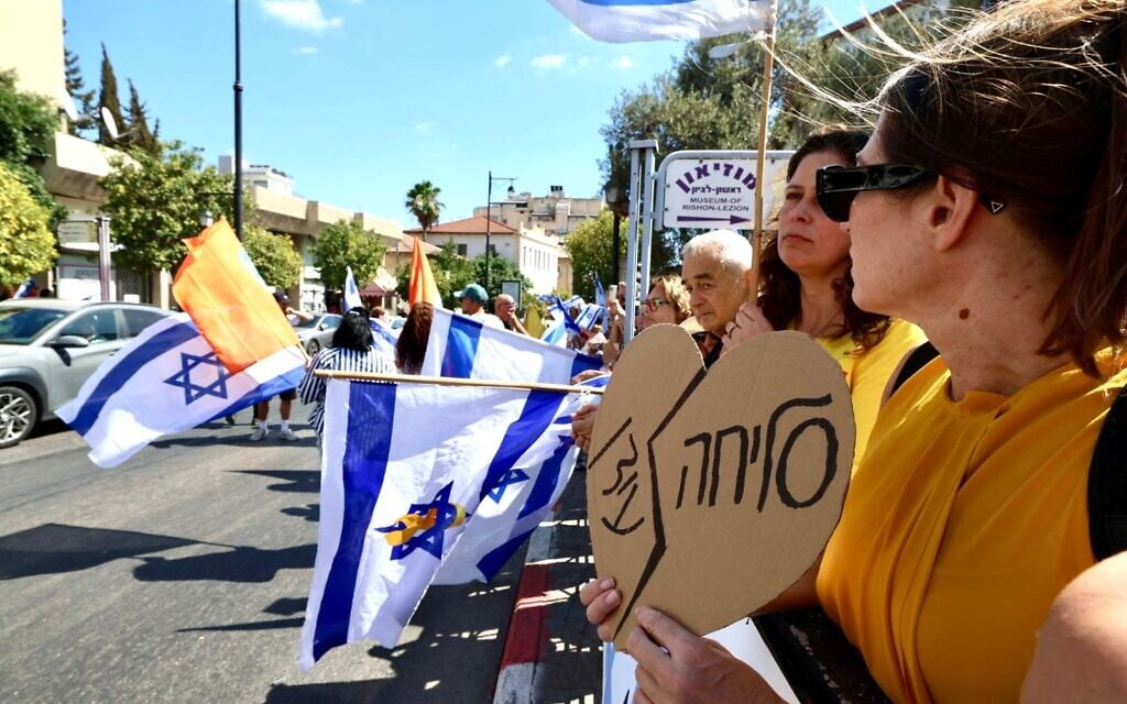 A woman holds a sign saying 'Sorry, Idan' at the funeral procession for slain hostage Idan Shtivi in Rishon Lezion on September 1, 2025 (Dafna Yosha/pro-democracy protest groups)