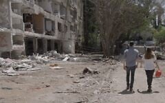 Filmmaker Eli Katzoff walks with Shir from the Lev Ehad organization at a site where an Iranian ballistic missile fell in June 2025. (courtesy)