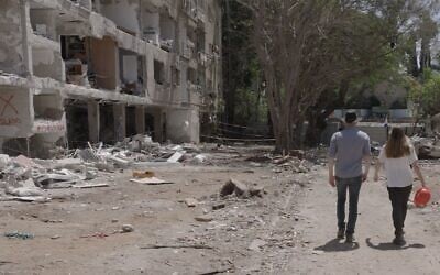 Filmmaker Eli Katzoff walks with Shir from the Lev Ehad organization at a site where an Iranian ballistic missile fell in June 2025. (courtesy)