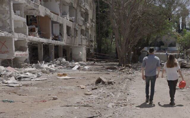 Filmmaker Eli Katzoff walks with Shir from the Lev Ehad organization at a site where an Iranian ballistic missile fell in June 2025. (courtesy)