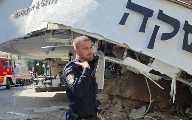 A police officer outside the Yashka shwarma restaurant where a balcony collapsed, on Dizengoff Street, Tel Aviv, September 27, 2025. (Israel Police) A police officer outside the Yashka shwarma restaurant where a balcony collapsed, on Dizengoff Street, Tel Aviv, September 27, 2025. (Israel Police)
