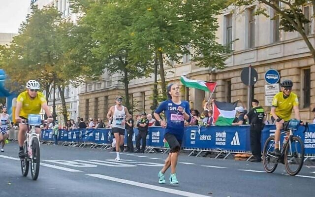 Security offers on bicycles flank runner Beatie Deutsch at the Berlin Marathon, Sep 21, 2025 (Courtesy)