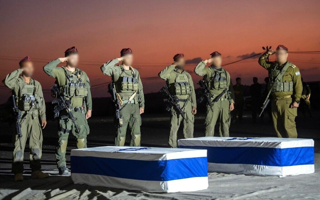 IDF troops salute over the caskets containing the bodies of slain hostages Amiram Cooper and Sahar Baruch in the Gaza Strip, October 30, 2025. (Israel Defense Forces)