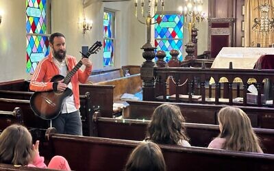 Yoni Kretzmer (standing) teaches the children at the Greenpoint Shul's newly incorporated Hebrew school. (Courtesy Greenpoint Shul via JTA)