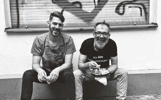 Jalil Dabit, right, wears a shirt that translates to 'I am a hummussexual.' He and Oz Ben David opened Kanaan in 2015. (Elisabeth Patrikiou via JTA)