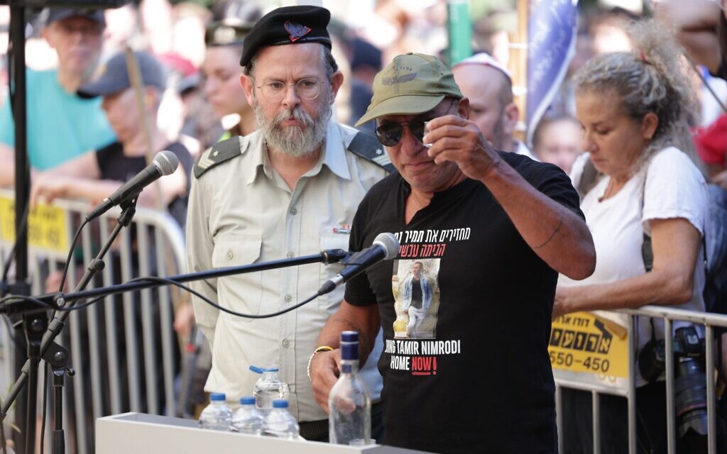 Alon Nimrodi, right, prepares to take a shot of vodka as he eulogizes his son Tamir, being laid to rest in Kfar Saba a day after Hamas returned his body, on October 16, 2025. (Alon Gilboa/Hostages Forum)