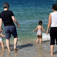 Omri Miran pictured at the beach with his wife Lishay and two daughters on October 17, 2025, soon after his discharge from the hospital, and four days after he was released from more than two years in Hamas captivity in Gaza. (Screenshot via X; Eli Teichman and Shir Katz)