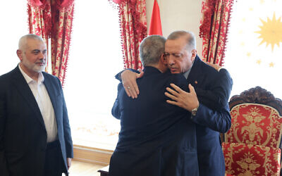 Turkish President Recep Tayyip Erdogan (R) embracing top Hamas official Khaled Mashaal (C) as he meets with then-leader of the terror group Ismail Haniyeh (L) and his delegation at the Dolmabahce Presidential working office in Istanbul, on April 20, 2024. (Handout / TURKISH PRESIDENTIAL PRESS SERVICE / AFP)