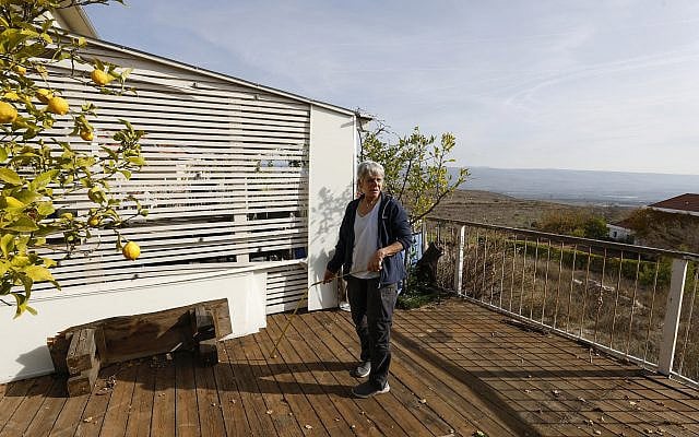 Illustrative: A Metula resident inspects damage on her home along the Lebanon border, on December 9, 2024, shortly after the ceasefire that halted the Hezbollah rockets. (Jalaa MAREY / AFP)