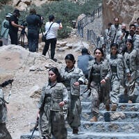 Fighters with the Kurdistan Workers' Party (PKK) descend stairs ahead of a ceremony in Sulaimaniyah, in Iraq's autonomous Kurdistan region, on July 11, 2025. (Shwan MOHAMMED / AFP)