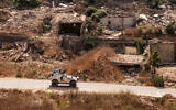 An armored vehicle of the United Nations Interim Force in Lebanon (UNIFIL) moves past destroyed buildings along a road in the village of Kfar Kila in southern Lebanon near the border with northern Israel on August 27, 2025. (ANWAR AMRO / AFP)