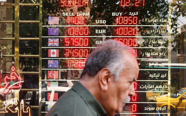A man walks past an electronic board displaying currency exchange rates in Ferdowsi Square in the Iranian capital Tehran on September 28, 2025. (ATTA KENARE / AFP) A man walks past an electronic board displaying currency exchange rates in Ferdowsi Square in the Iranian capital Tehran on September 28, 2025. (ATTA KENARE / AFP)