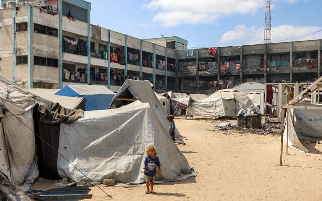 A girl stands outside one of the tents erected at a make-shift camp for people displaced by conflict in the yard of a school run by the United Nations Relief and Works Agency (UNRWA), in Khan Younis in the southern Gaza Strip on September 30, 2025.(Omar AL-QATTAA / AFP)
