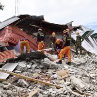 Rescuers search for three people who were reported missing under the rubble of a collapsed building in Bogo City on October 1, 2025, after a powerful 6.9 magnitude earthquake jolted the central Philippines. (TED ALJIBE / AFP)