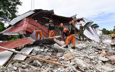 Rescuers search for three people who were reported missing under the rubble of a collapsed building in Bogo City on October 1, 2025, after a powerful 6.9 magnitude earthquake jolted the central Philippines. (TED ALJIBE / AFP)