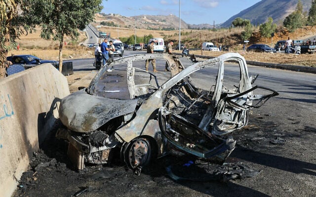 Lebanese emergency and security service members deploy around the wreckage of a car hit by an Israeli drone strike in the southern area of Al-Jarmak on October 2, 2025. (Rabih Daher/AFP)