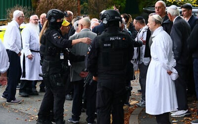 Armed police officers talk with members of the community near Heaton Park Hebrew Congregation synagogue in Crumpsall, north Manchester, on October 2, 2025 (Paul Currie / AFP)