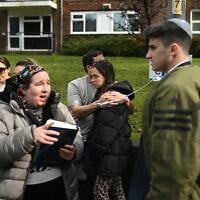 Members of the community comfort each other near Heaton Park Hebrew Congregation Synagogue in Crumpsall, north Manchester, after a deadly terrorist attack on October 2, 2025 (Oli SCARFF / AFP)