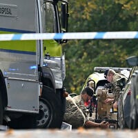 Members of the Armed Forces work by a bomb disposal van as they prepare a Harris T7 Multi-Mission Robot inside a police cordon at Heaton Park Hebrew Congregation synagogue in Crumpsall, north Manchester, on October 2, 2025 (Oli SCARFF / AFP)