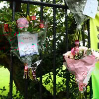 Flowers and messages of condolence are pictured by a police cordon on the main road outside Heaton Park Hebrew Congregation synagogue in Crumpsall, north Manchester, on October 3, 2025, following a deadly terror attack at the synagogue. (Paul Currie / AFP)