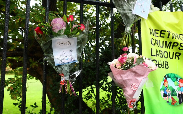 Flowers and messages of condolence are pictured by a police cordon on the main road outside Heaton Park Hebrew Congregation synagogue in Crumpsall, north Manchester, on October 3, 2025, following a deadly terror attack at the synagogue. (Paul Currie / AFP)