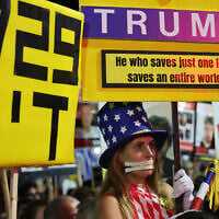 A woman dressed in a costume in the colors of the US flag holds a sign urging US President Donald Trump to seal a Gaza ceasefire-hostage deal, during a rally in support of the hostages at Hostages Square in Tel Aviv, October 4, 2025. (Jack GUEZ / AFP)
